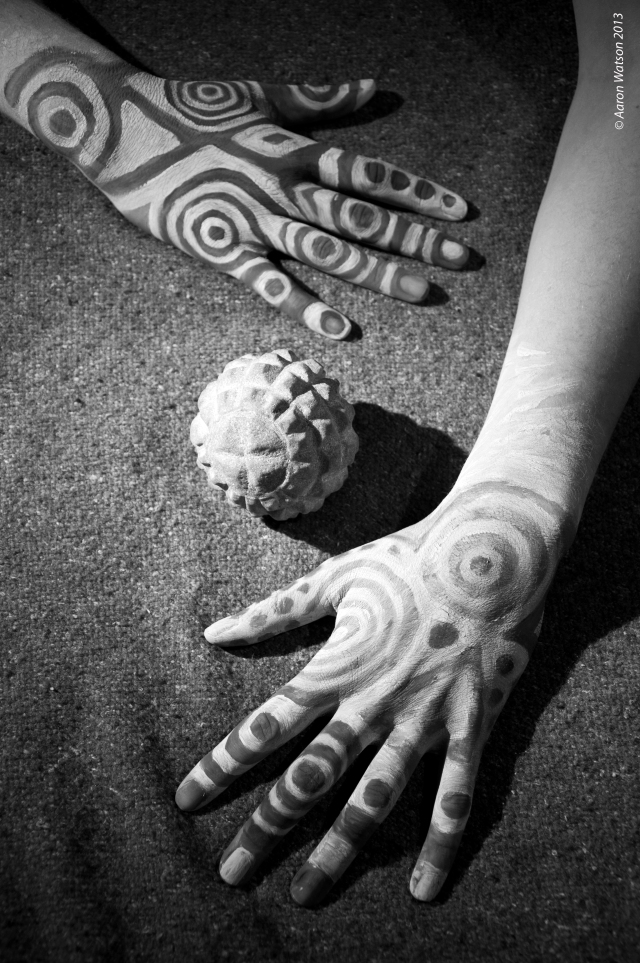 Painted hands and a carved stone ball.